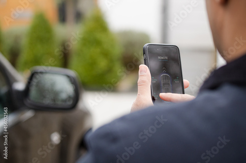 Personal perspective man setting car alarm from smart phone