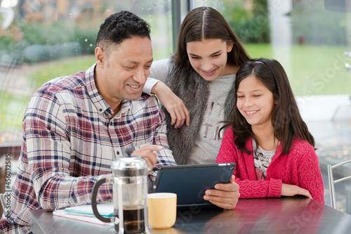 Wallpaper Mural Father and daughters using digital tablet in morning kitchen Torontodigital.ca