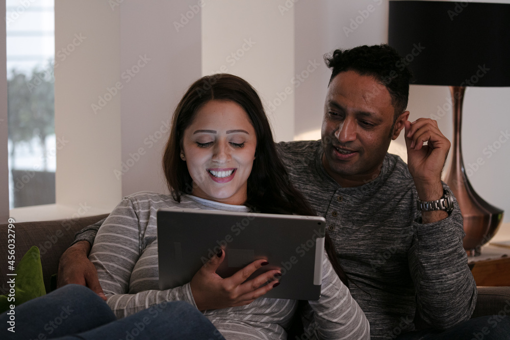 Couple relaxing, using digital tablet on living room sofa Couple relaxing, using digital tablet on living room sofa