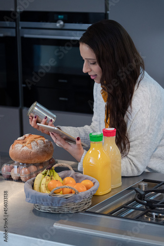 Smiling woman with digital tablet  in kitchen