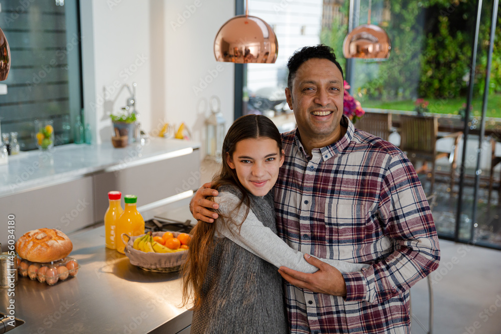 Portrait happy father and daughter hugging in kitchen Portrait happy father and daughter hugging in kitchen