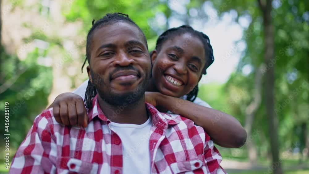 Loving girlfriend hugging serious boyfriend, African couple smiling, support