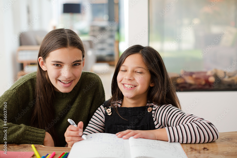 Girl helping young sister with homework Girl helping young sister with homework