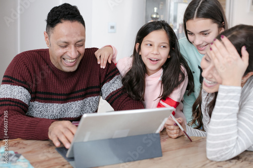 Family using digital tablet at kitchen table