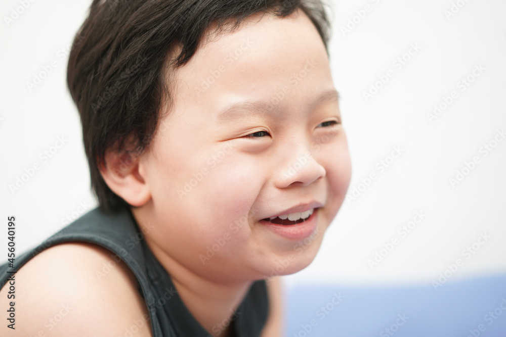 Asia boy child face smile and laugh look away camera head shot portrait with copy space Asia boy child face smile and laugh look away camera head shot portrait with copy space