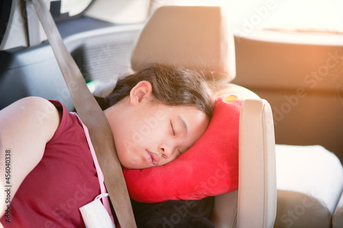 Asian girl kid sleep in car with pillow and seatbelt for safety ride car travel concept