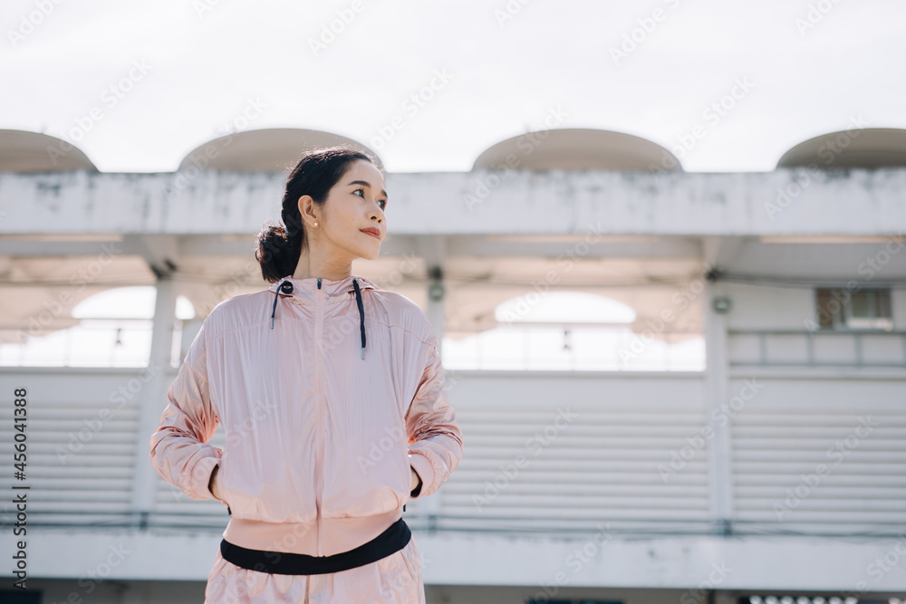 A beautiful woman stretching her body before running in the morning with a bright smile on her face. women's health care concept A beautiful woman stretching her body before running in the morning with a bright smile on her face. women's health care concept