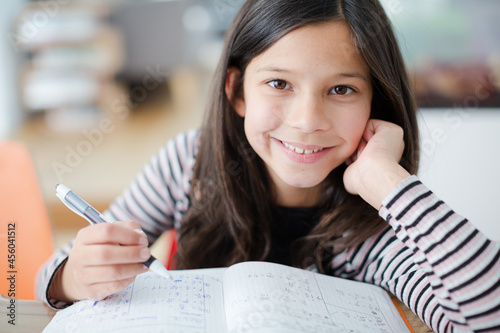 Portrait confident, smiling girl doing homework