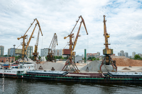 Port work loading and unloading the barge with sand and gravel