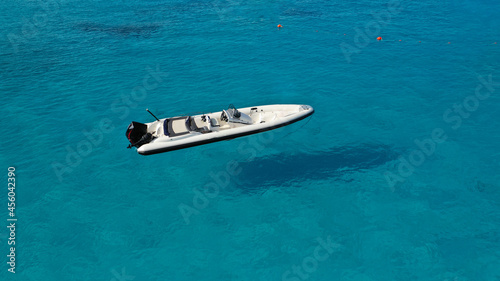 Aerial top view photo of speed inflatable boat anchored in tropical Caribbean turquoise bay with calm sea © aerial-drone