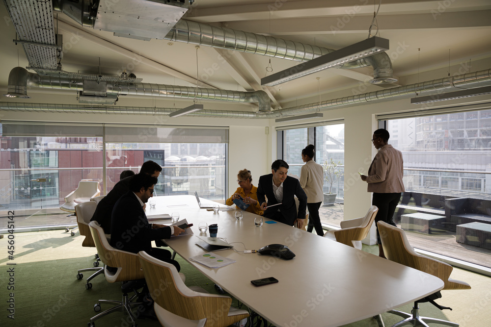Business people leaving conference room after meeting Business people leaving conference room after meeting