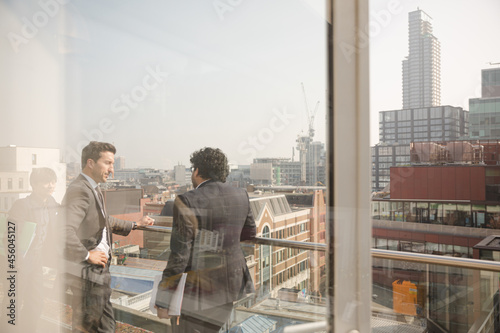 Two businessmen talking on balcony