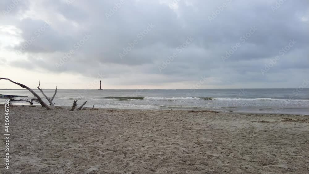 Beautiful the most powerful in the world Coastal red an white Lighthouse standing on top of an s sand dunes rising above Ocean in cloudy weather. Maritime Navigation. Beach Tropical Travel 4k Beautiful the most powerful in the world Coastal red an white Lighthouse standing on top of an s sand dunes rising above Ocean in cloudy weather. Maritime Navigation. Beach Tropical Travel 4k