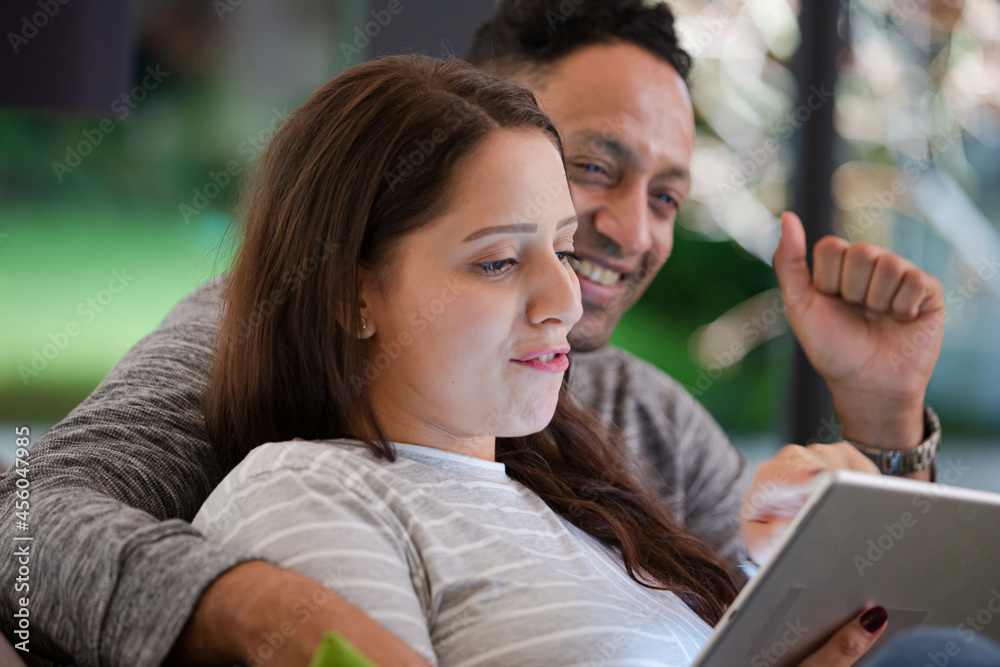 Couple relaxing, using digital tablet on living room sofa Couple relaxing, using digital tablet on living room sofa