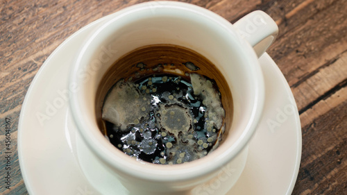 Black moldy coffee, fungus blooming coffee drink in a cup. photo