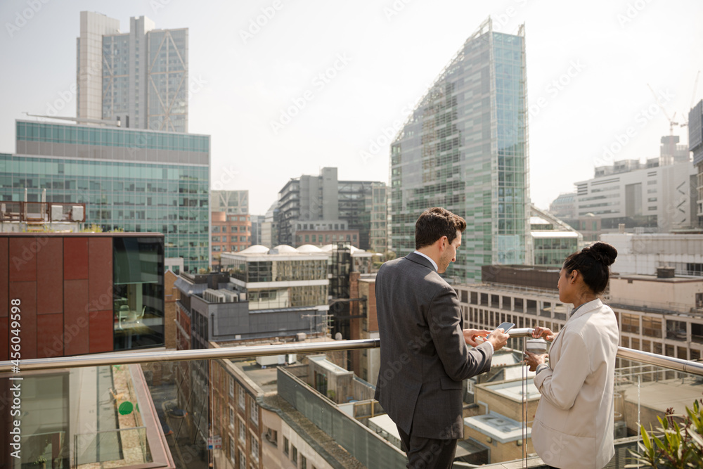Businessman and businesswoman talking on balcony Businessman and businesswoman talking on balcony