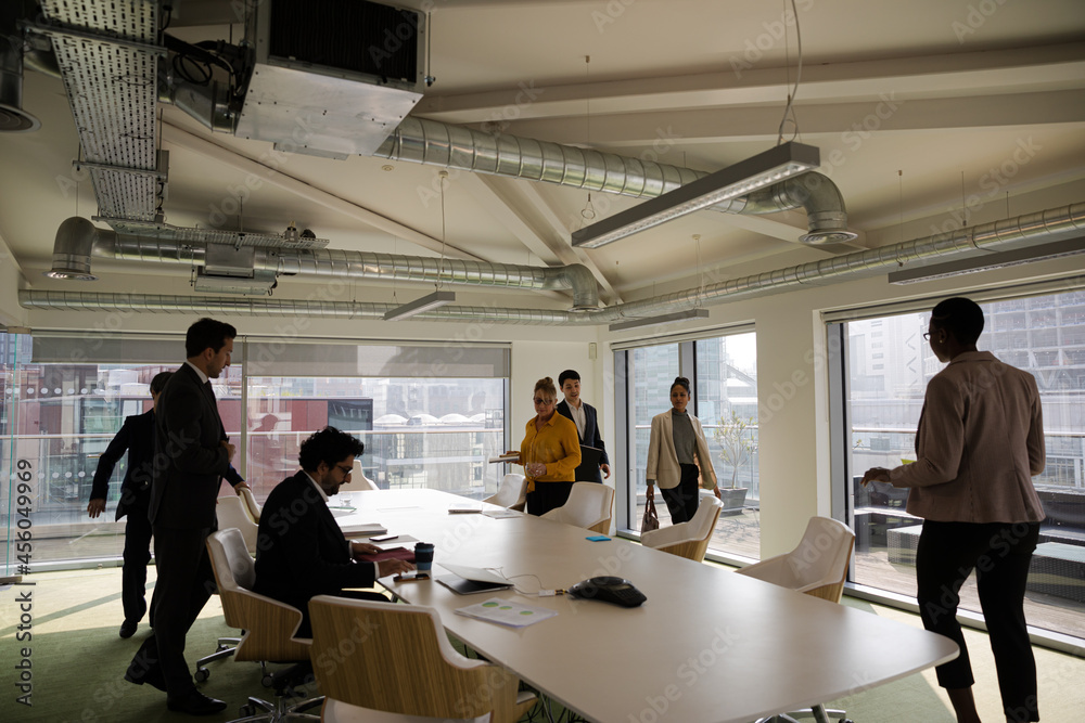 Business people leaving conference room after meeting Business people leaving conference room after meeting