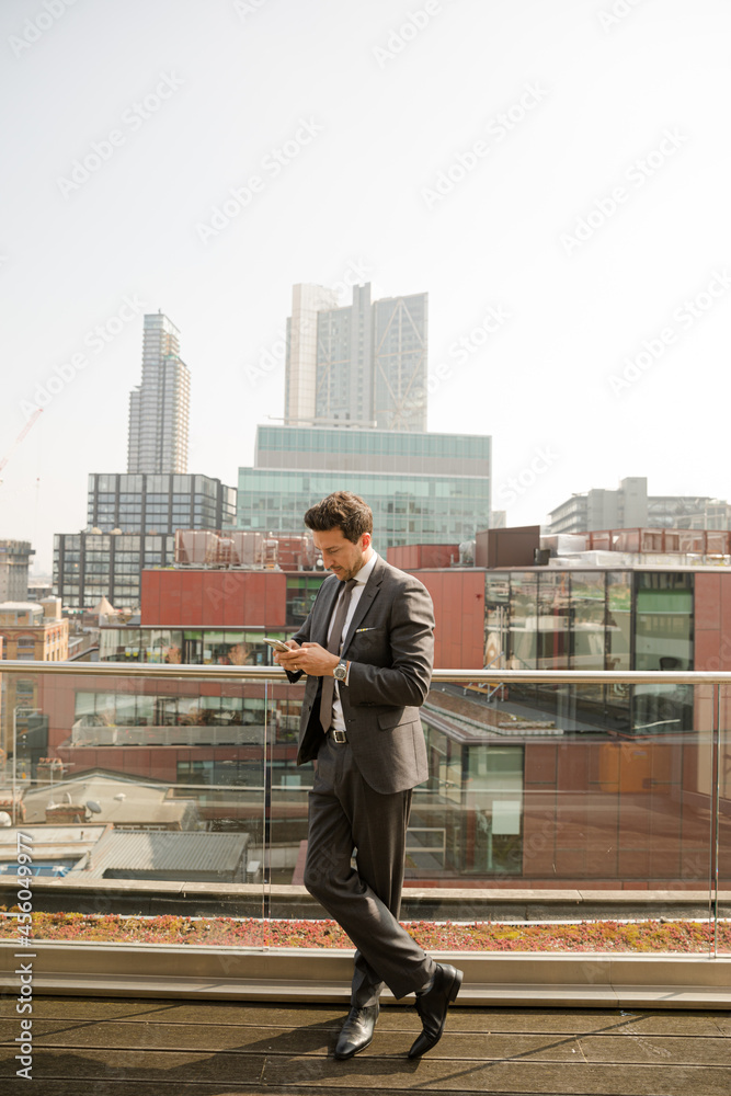 Businessman using smarpthone on balcony Businessman using smarpthone on balcony