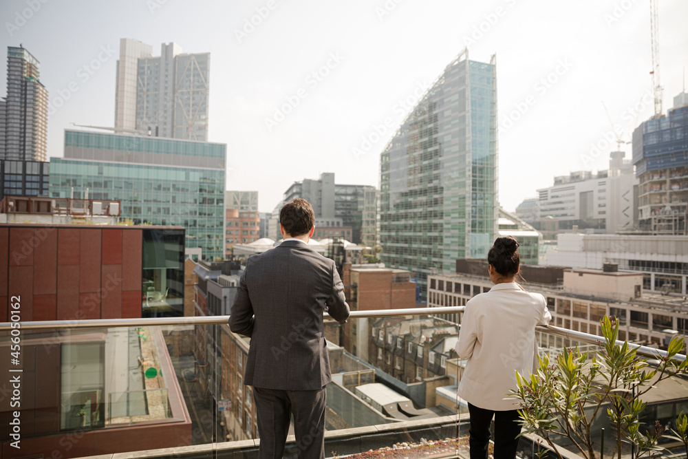 Businessman and businesswoman talking on balcony Businessman and businesswoman talking on balcony