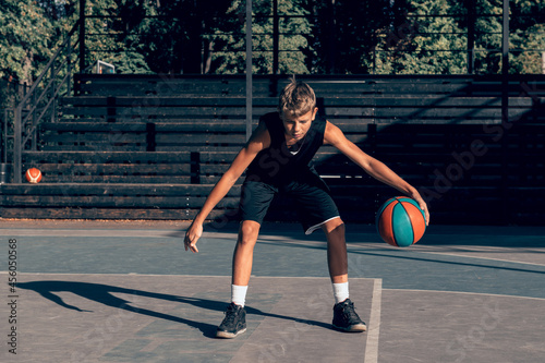 Fotografia Teenager boy basketball player dribbling on sports ground