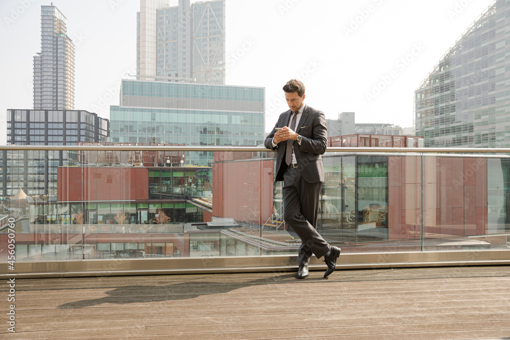 Businessman using smarpthone on balcony Businessman using smarpthone on balcony