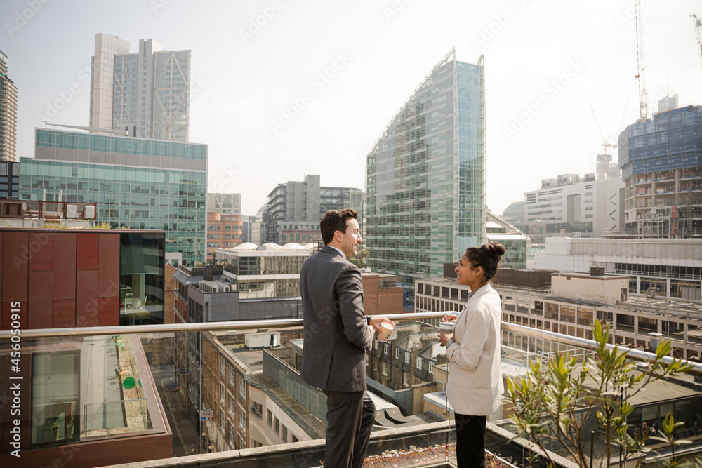 Businessman and businesswoman talking on balcony Businessman and businesswoman talking on balcony