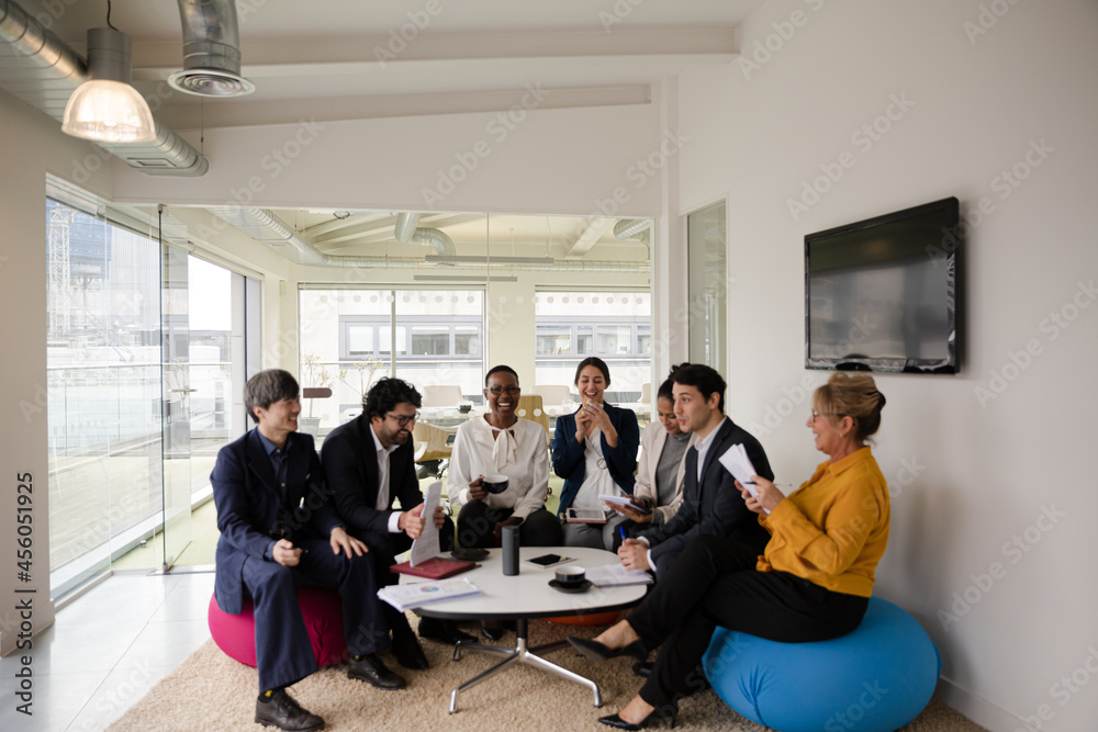 Business people discussing paperwork in relax zone Business people discussing paperwork in relax zone