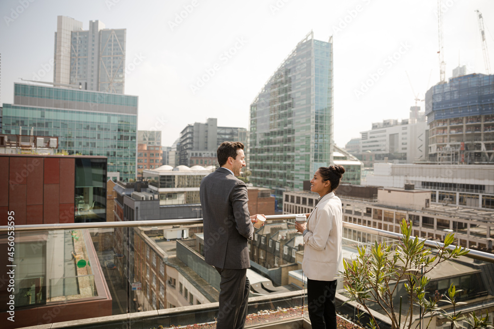 Businessman and businesswoman talking on balcony Businessman and businesswoman talking on balcony