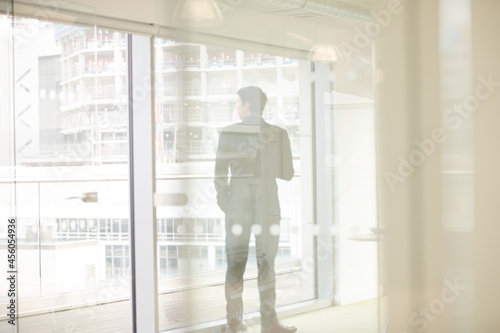 Businessman standing by window in conference room