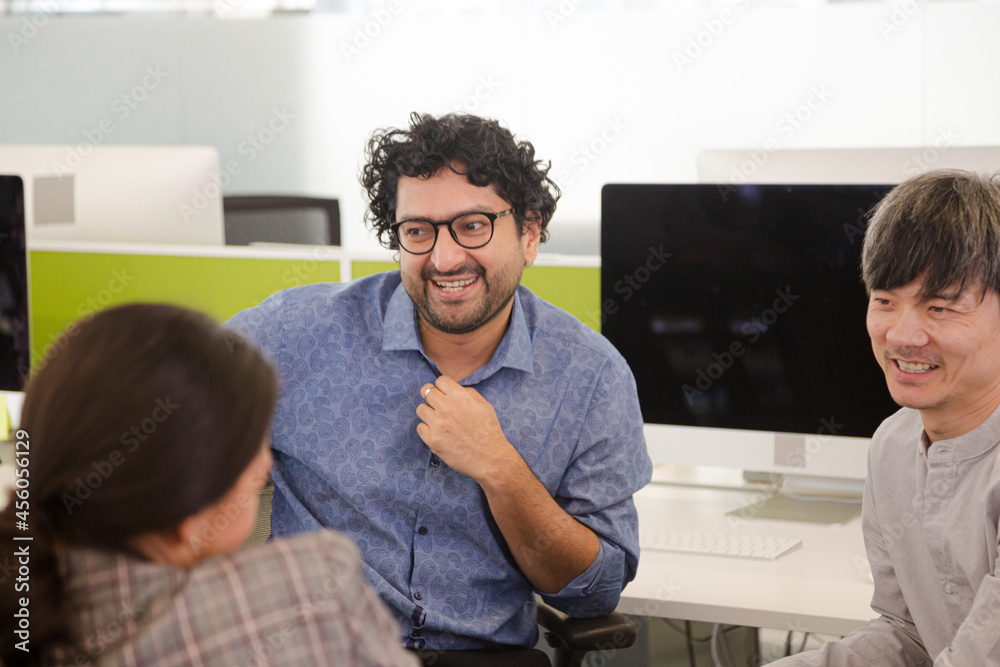 Business people talking in open plan office Business people talking in open plan office