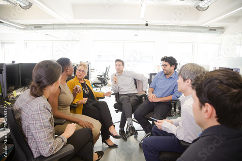 Business people meeting at computer in open plan office