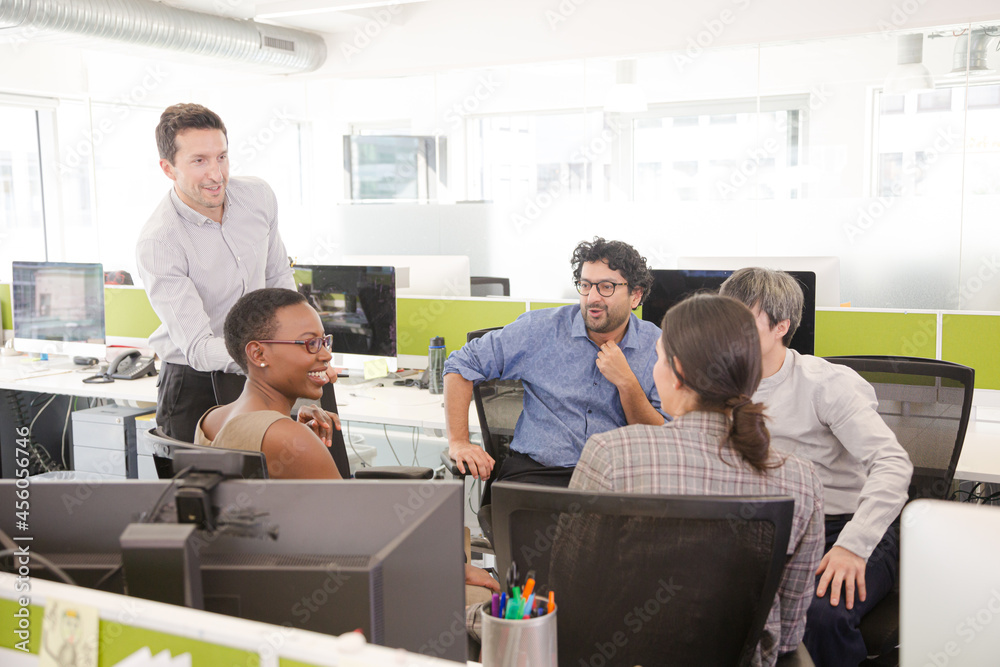 Business people meeting at computer in open plan office Business people meeting at computer in open plan office
