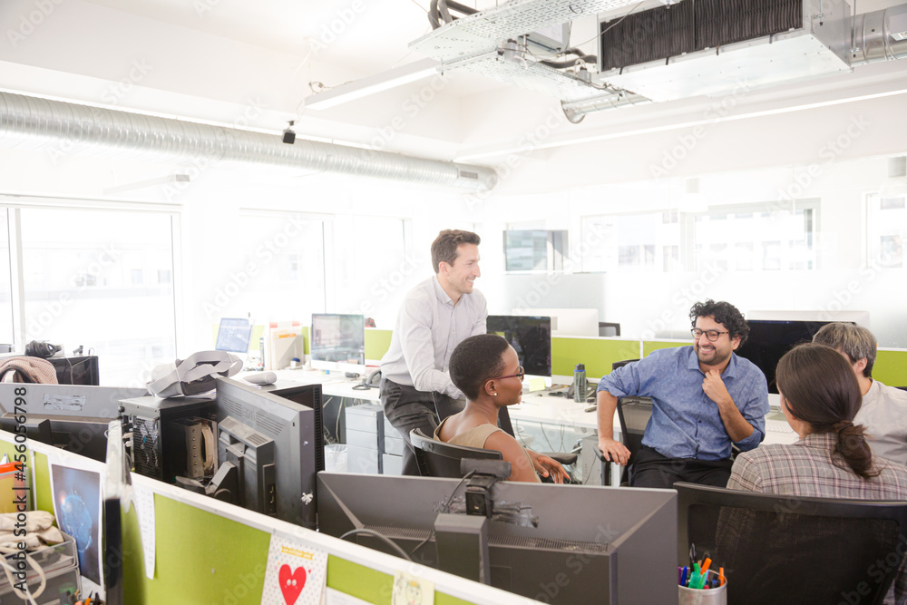 Business people meeting at computer in open plan office