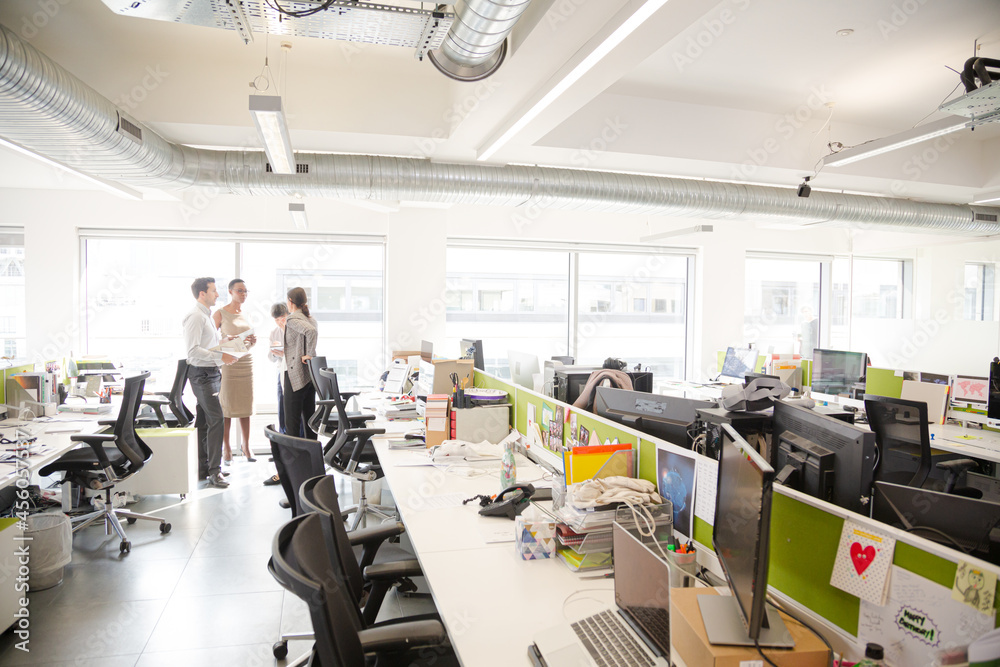 Business people talking in open plan office Business people talking in open plan office