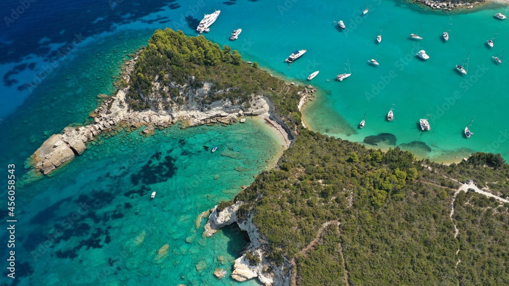 Aerial drone photo of luxury yachts and sail boats anchored in tropical exotic island emerald bay with crystal clear calm sea