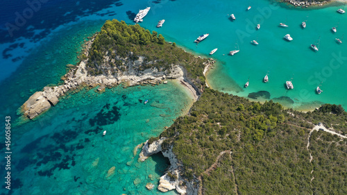 Aerial drone photo of luxury yachts and sail boats anchored in tropical exotic island emerald bay with crystal clear calm sea