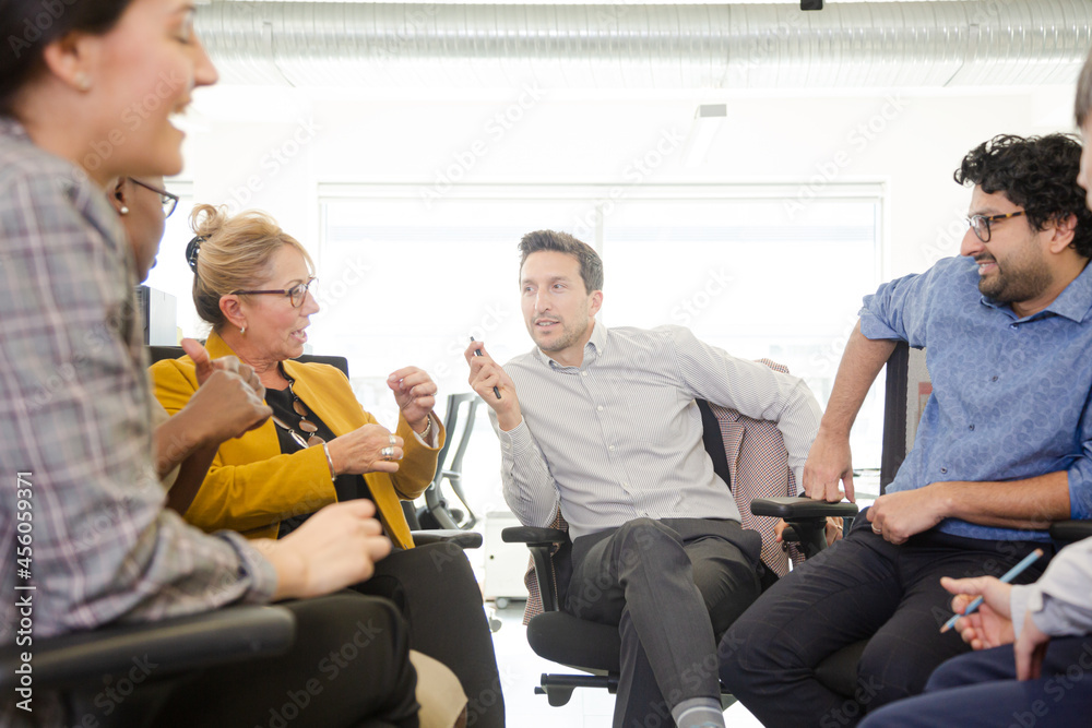 Business people meeting at computer in open plan office Business people meeting at computer in open plan office