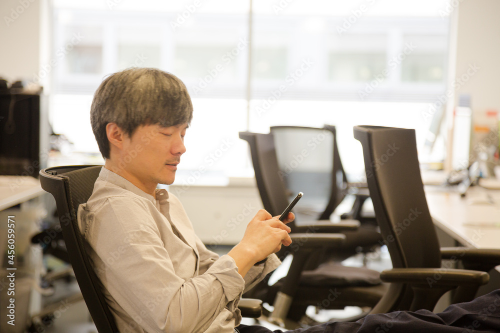 Portrait confident businessman using smartphone in office