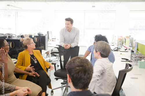 Business people meeting at computer in open plan office