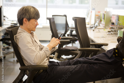 Portrait confident businessman using smartphone in office © KOTO