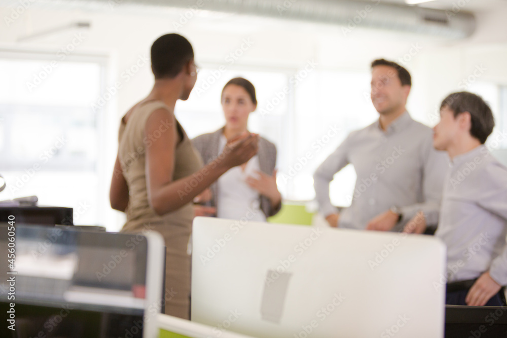 Business people talking in open plan office Business people talking in open plan office