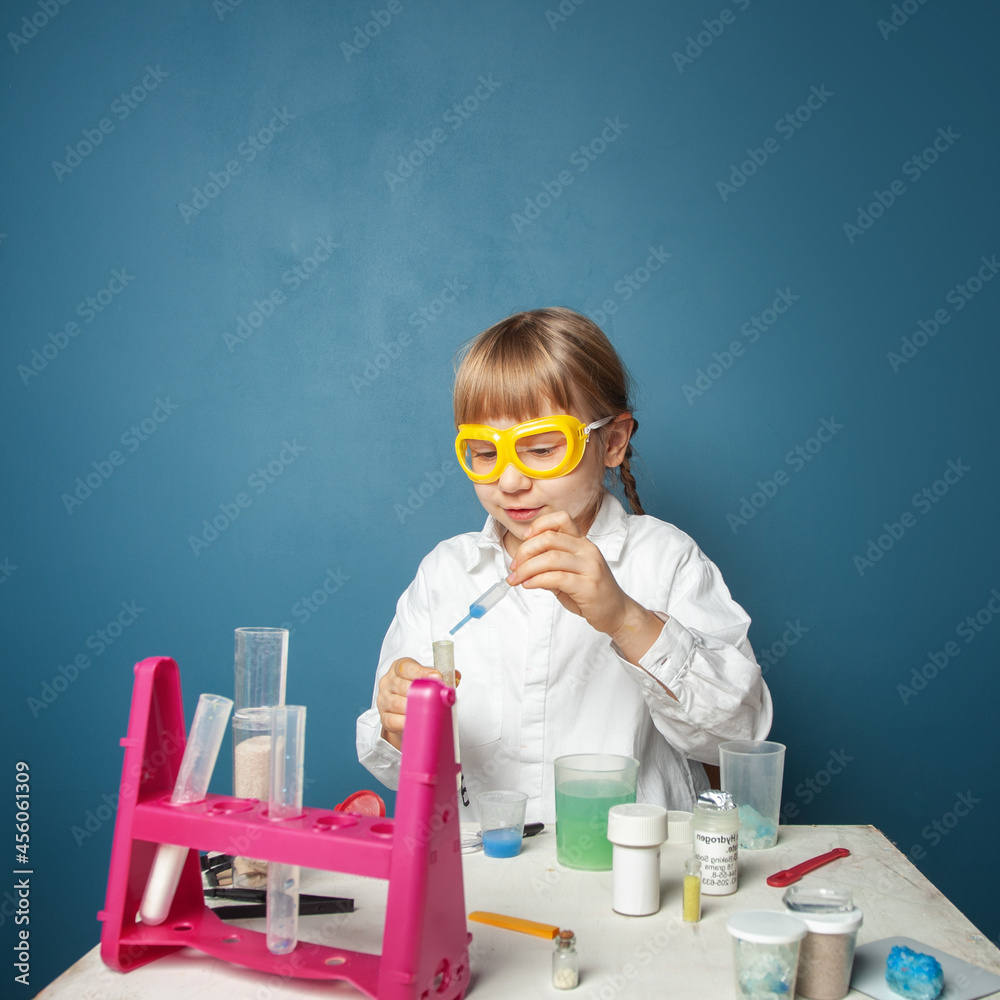 Little child girl doing a chemistry experiment in science class Little child girl doing a chemistry experiment in science class