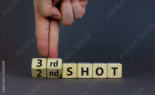 Covid-19 booster vaccine shot symbol. Doctor turns cubes and changes words '2nd shot' to '3rd shot'. Beautiful grey background, copy space. Covid-19 booster vaccine shot concept.