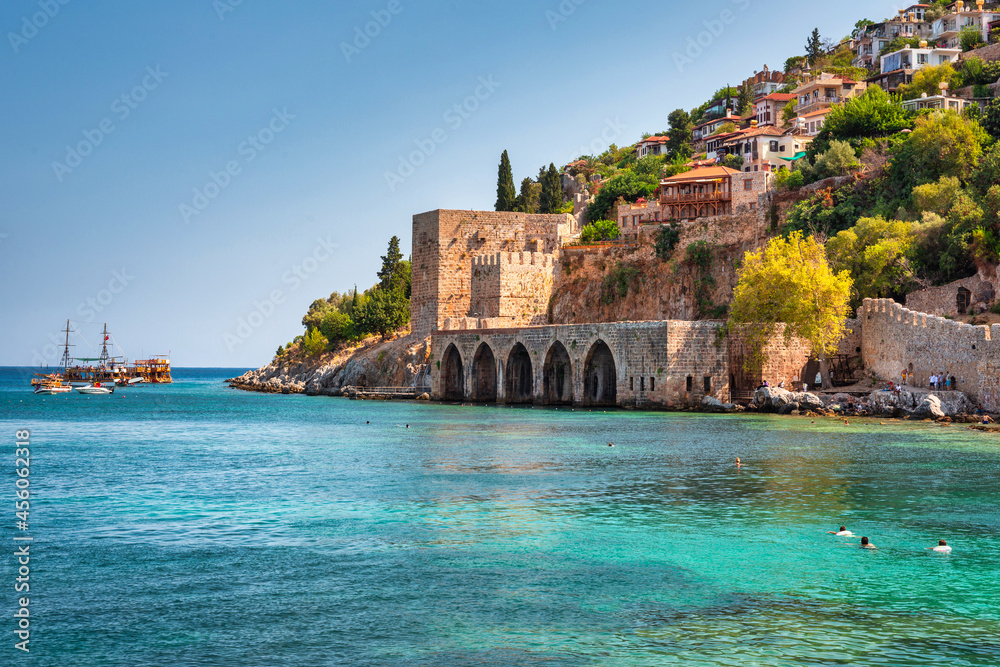 Beautiful Mediterranean Sea beach against the city walls of Alanya, Turkey