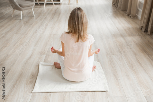 woman sitting on the mat doing yoga, woman in light room