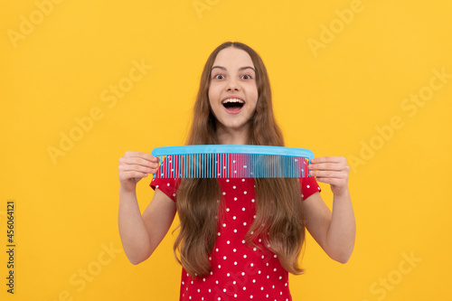 hairdresser. girl has wavy hairdo hold hairbrush. teen beauty hairstyle. portrait of frizz child