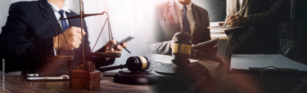 Justice and law concept.Male judge in a courtroom with the gavel, working with, computer and docking keyboard, eyeglasses, on table in morning light Justice and law concept.Male judge in a courtroom with the gavel, working with, computer and docking keyboard, eyeglasses, on table in morning light