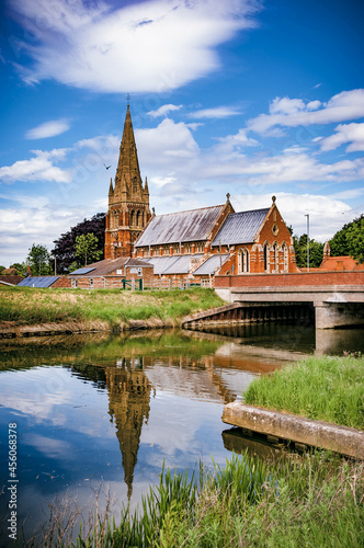 St Paul's Church, Fulney, Spalding, Lincolnshire, UK with reflection in the Coronation Channel against a fair weather sky photo