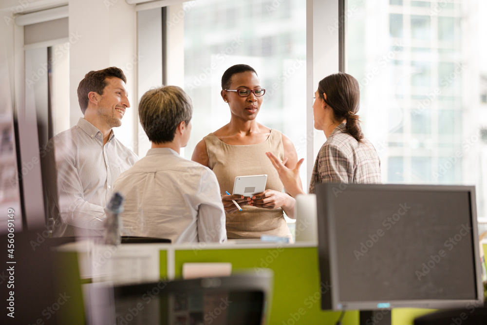 Business people talking in open plan office