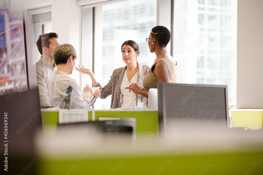 Business people talking in open plan office
